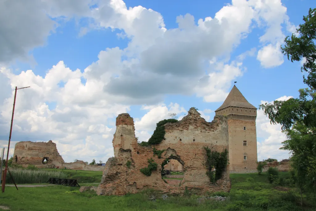The keep and ruined walls of the medieval Bač Fortress under a blue sky