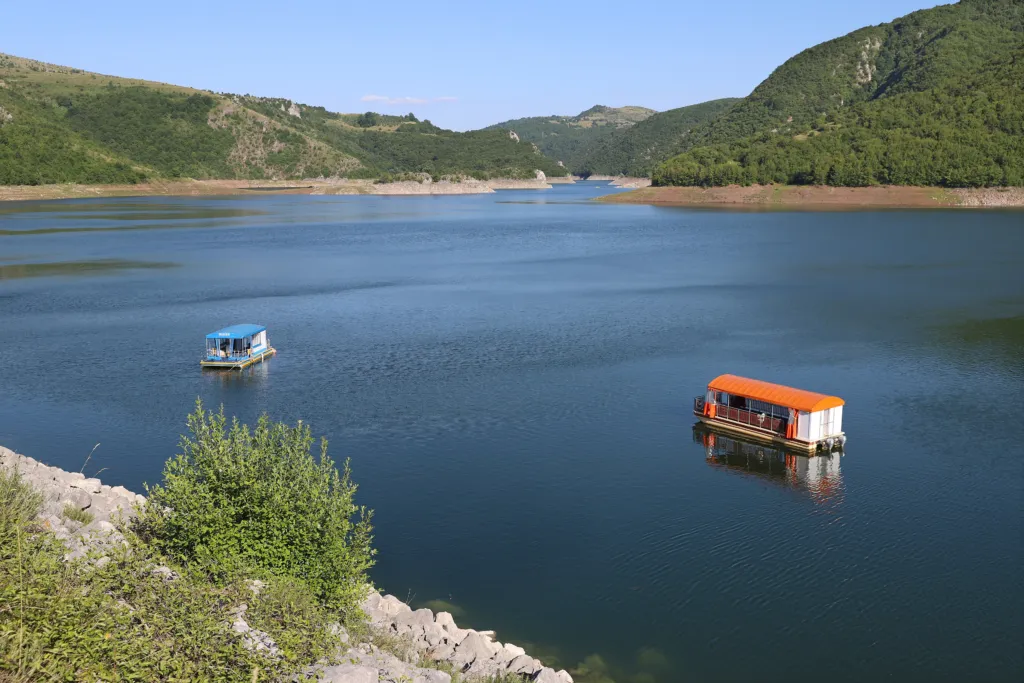 Small boats on the deep blue Uvac lake between green hills