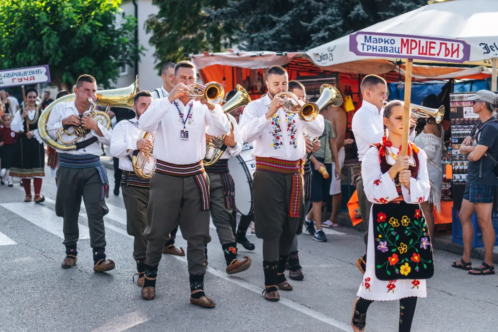 A brass band in folk costume parading at the Guča trumpet festival