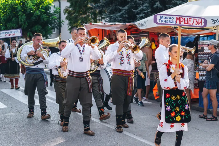 A brass band in folk costume parading at the Guča trumpet festival