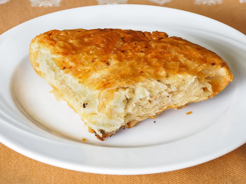 A slice of flaky meat burek on a plate