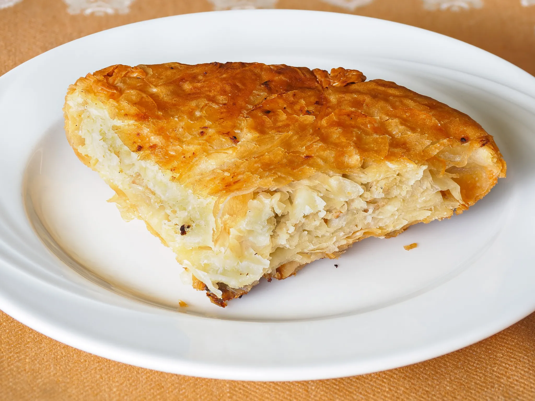 A slice of flaky meat burek on a plate
