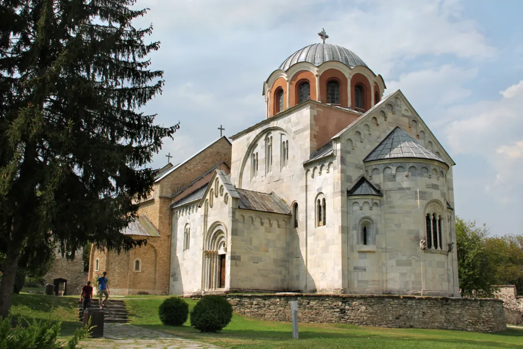 The white marble Church of the Virgin at Studenica Monastery among pine trees