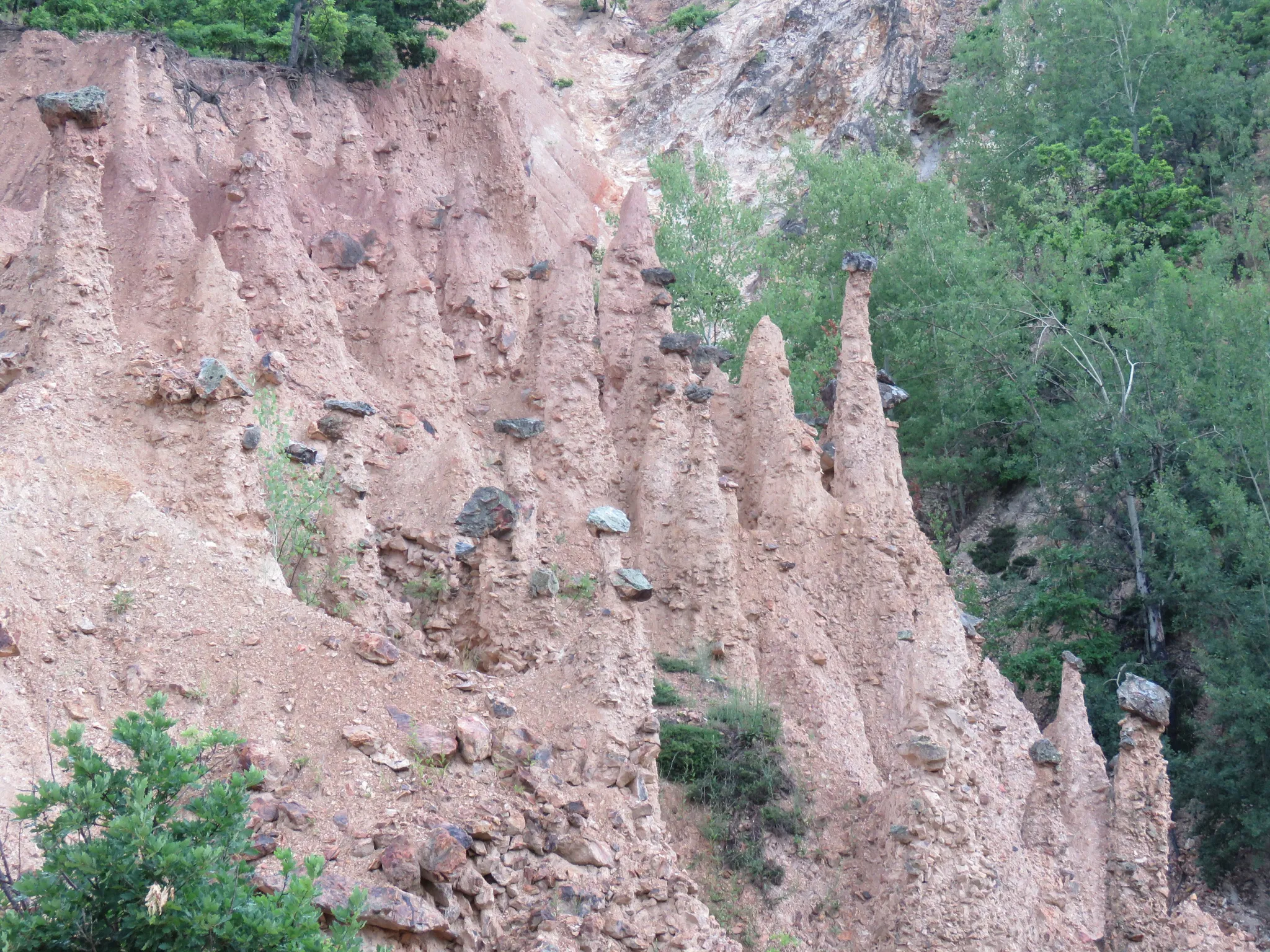 Pink earth pillars capped with stones at Đavolja Varoš
