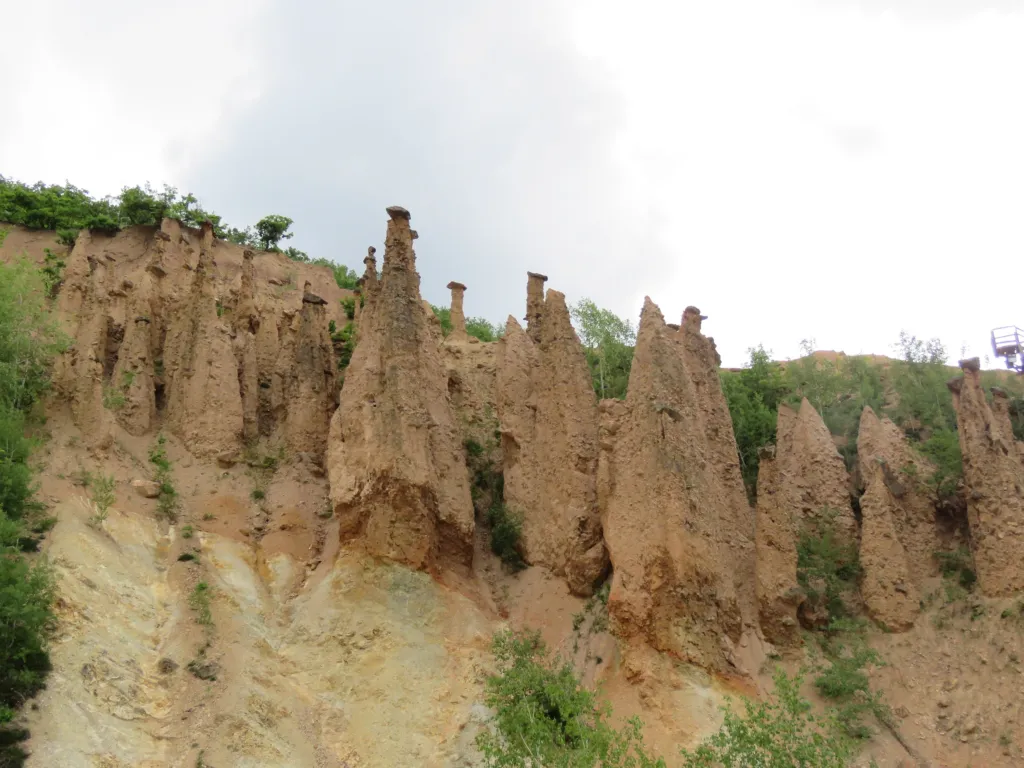 The row of earth pillars of Đavolja Varoš above a green slope