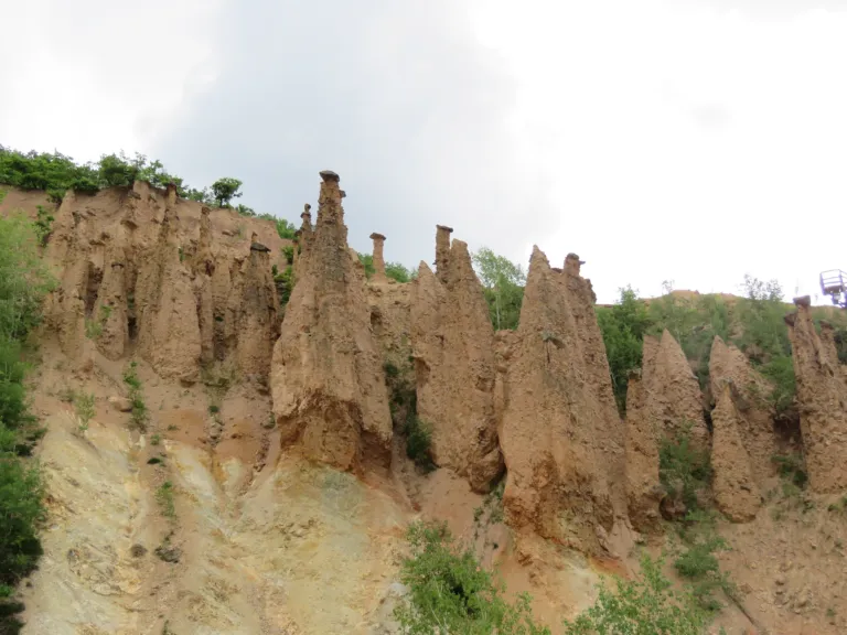 The row of earth pillars of Đavolja Varoš above a green slope
