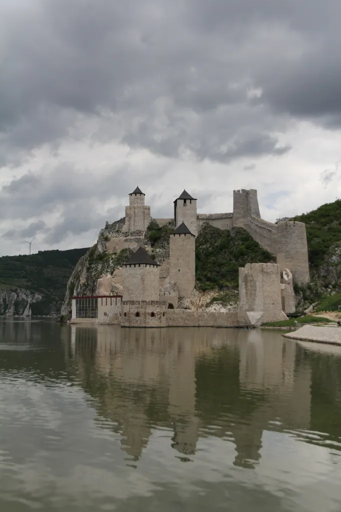 The towers of Golubac Fortress rising from the Danube below a wooded cliff