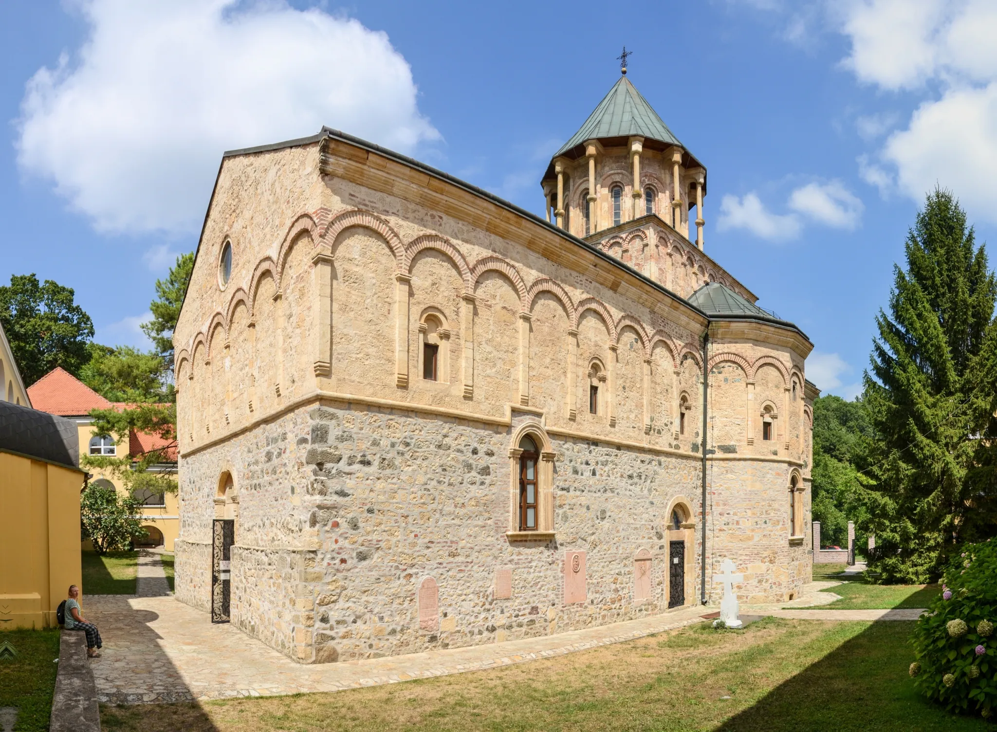 The stone church of Novo Hopovo Monastery among trees on Fruška Gora
