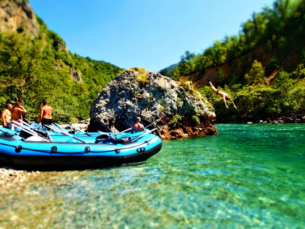 A rafting boat on the clear green water of the Tara river canyon
