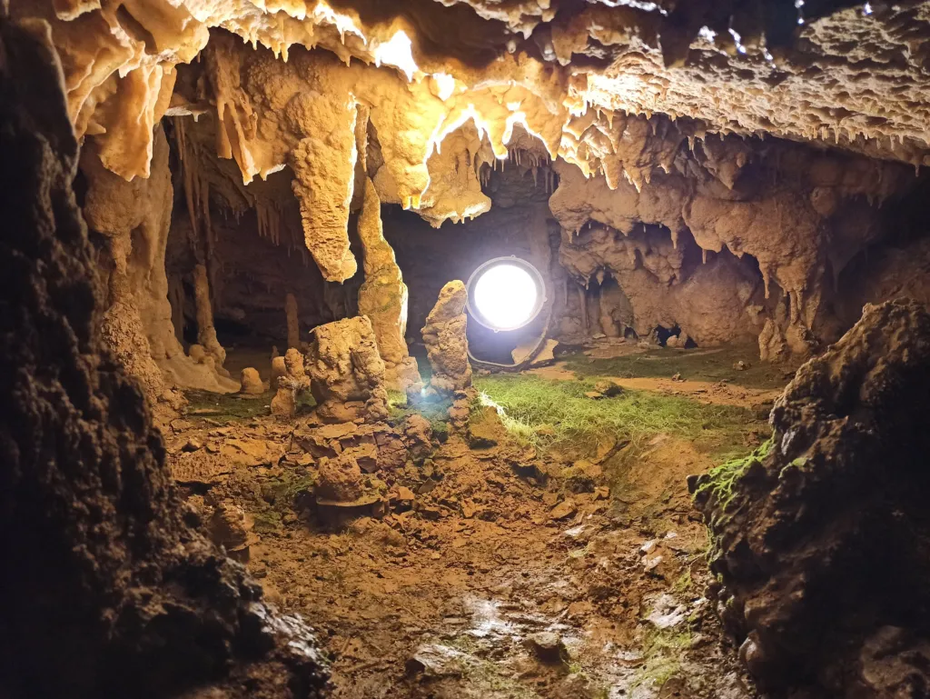 A lamp-lit chamber with stalactites and flowstone in Resava Cave