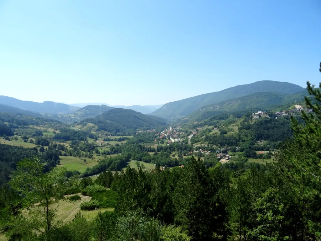 Wooded hills and the valley below seen from the Šargan Eight narrow-gauge train near Mokra Gora