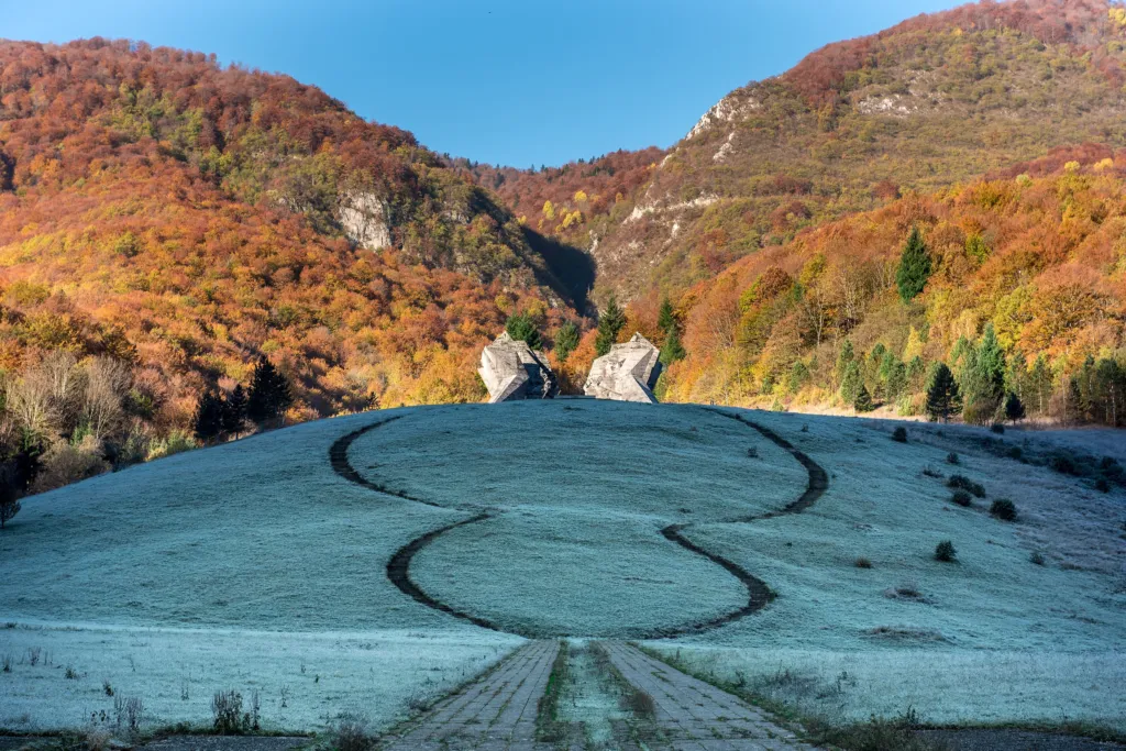 The concrete Sutjeska battle memorial at Tjentište among autumn hills