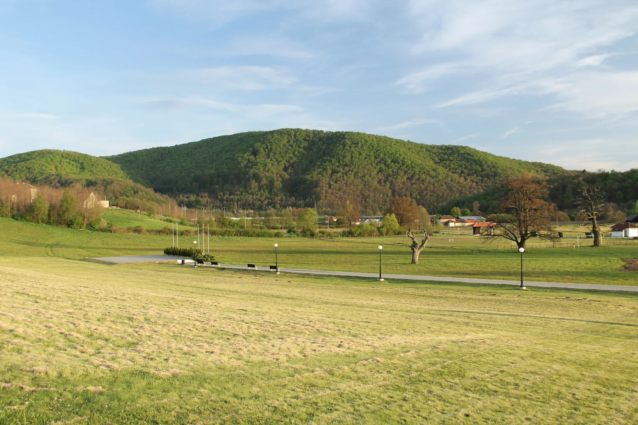 The open meadow of the Takovo uprising memorial complex below the green Šumadija hills