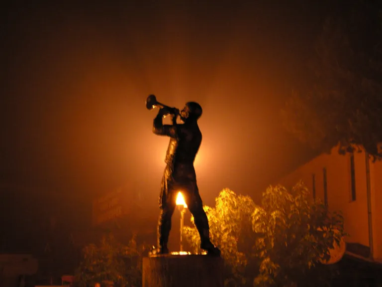 The bronze trumpeter statue in Guča lit at night