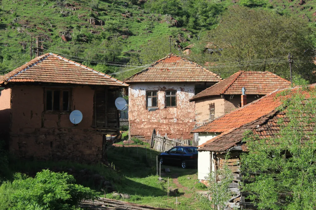 Stone houses with red roofs in the mountain village of Topli Do