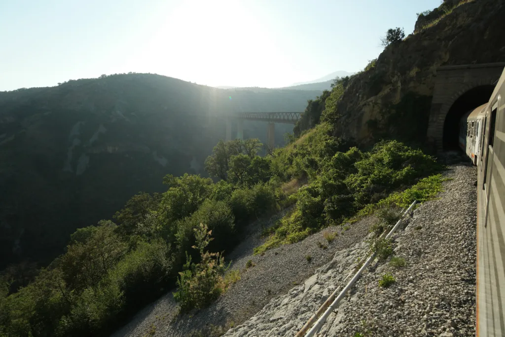 A passenger train coming out of a mountain tunnel towards the Mala Rijeka viaduct, Montenegro